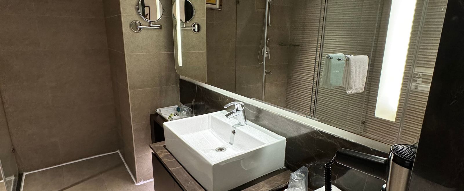 A modern bathroom with a sleek sink, mirror, and countertop at Cenneys Gateway.