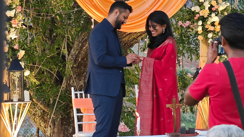 Bride and groom exchanging rings at an altar under a tree, surrounded by seated guests in an outdoor wedding in Coonoor - Ibex Stays & Trails, Coonoor (Leewood).