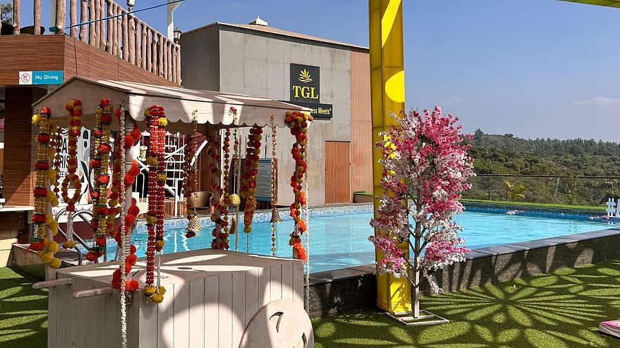 A carnival theme decorated area near swimming pool at The Grand Legacy Resort & Spa featuring a cart with wheels which is decorated with flowers and there are pillars around supporting cut out fabric page design - The Grand Legacy Resort & Spa