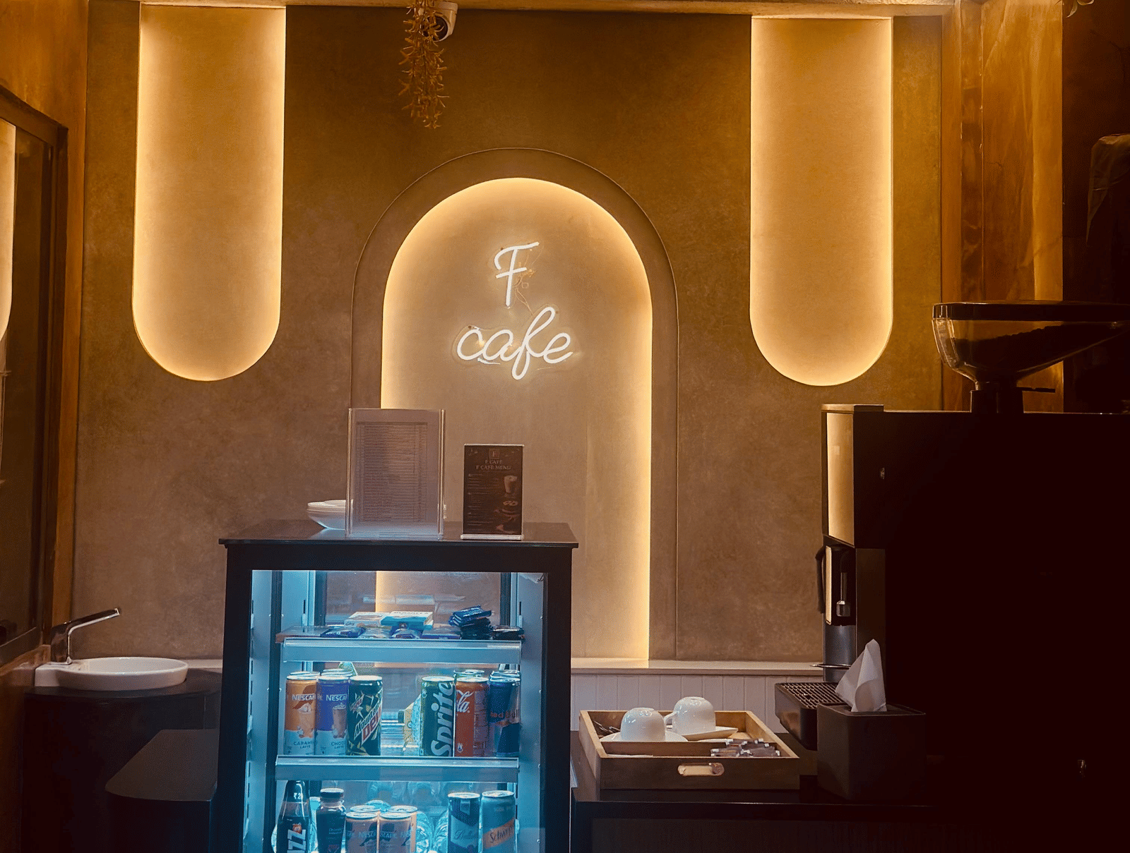 Front view of the F Cafe featuring a mini fridge with transparent door at F Hotels, Bengaluru.