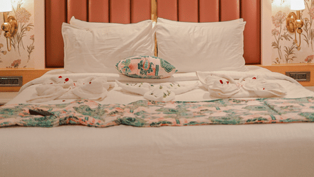 Bedroom with upholstered headboard and wall panels at Hotel Mumbai House, Digha, Airoli.