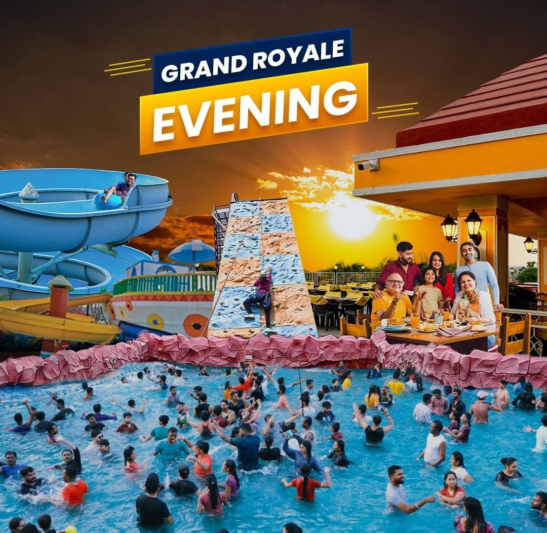 Grand Royale Evening showcasing a crowd in a swimming pool at Diamond Waterparks, Pune. The people there are enjoying various water rides and other rides in the evening.
