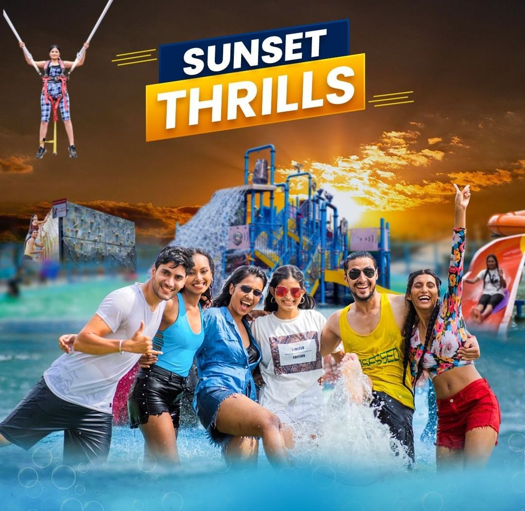 Sunset Thrills package at Diamond Waterparks, Pune featuring a group of youngsters playing with water in swimming pool and behind them is a poster showcasing various water rides.