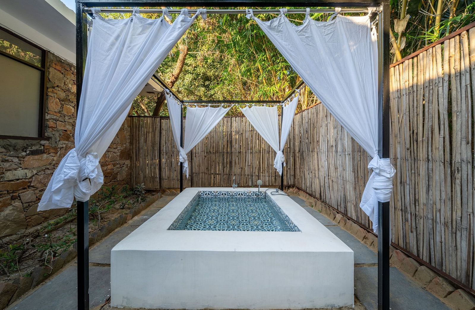 A swimming pool at Valley by Grassfield, surrounded by pathways and featuring curtains around it.