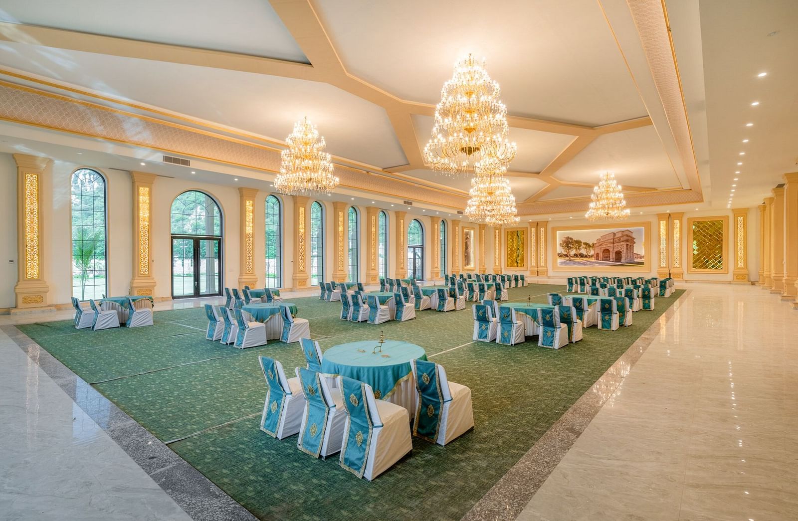 Back view of a banquet hall at Valley by Grassfield, showcasing a well-arranged table and chair setup with large windows on the side.