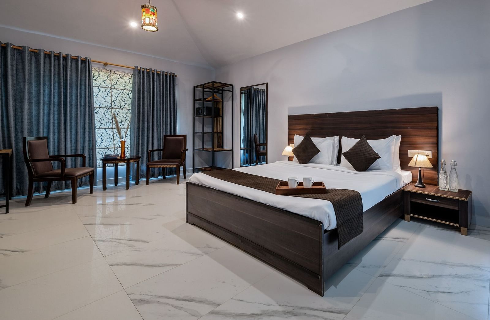 A room at Valley by Grassfield featuring a bed and a seating area with two chairs and a table.