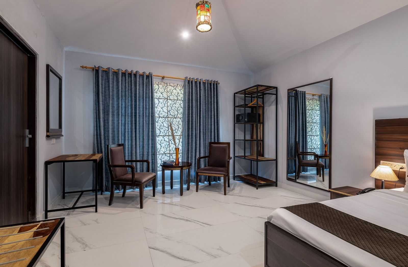 A room with a bed and a seating area beside the window at Valley by Grassfield.