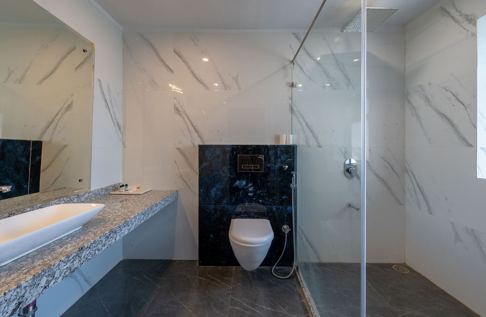 A washroom with a sink, a toilet, and a shower area at Valley by Grassfield.