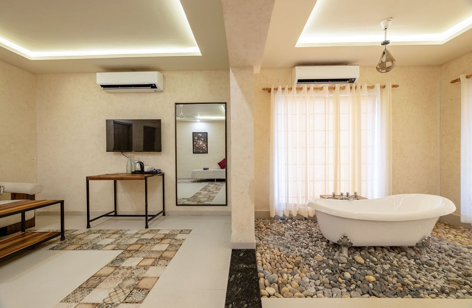 Front view of a seating area and a bathtub, separated by a half-wall, at Valley by Grassfield.