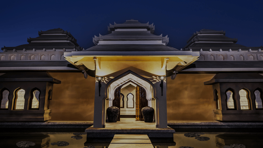 Illuminated ornate resort entrance gate at night at Evolve Back Hampi