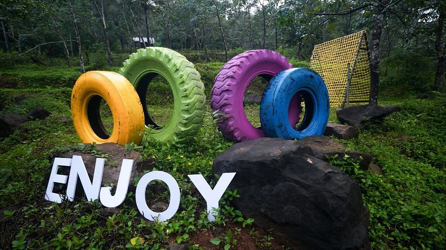 many types painted in different colours with the words enjoy below it - Holistic Stay Eco Resort, Kannur