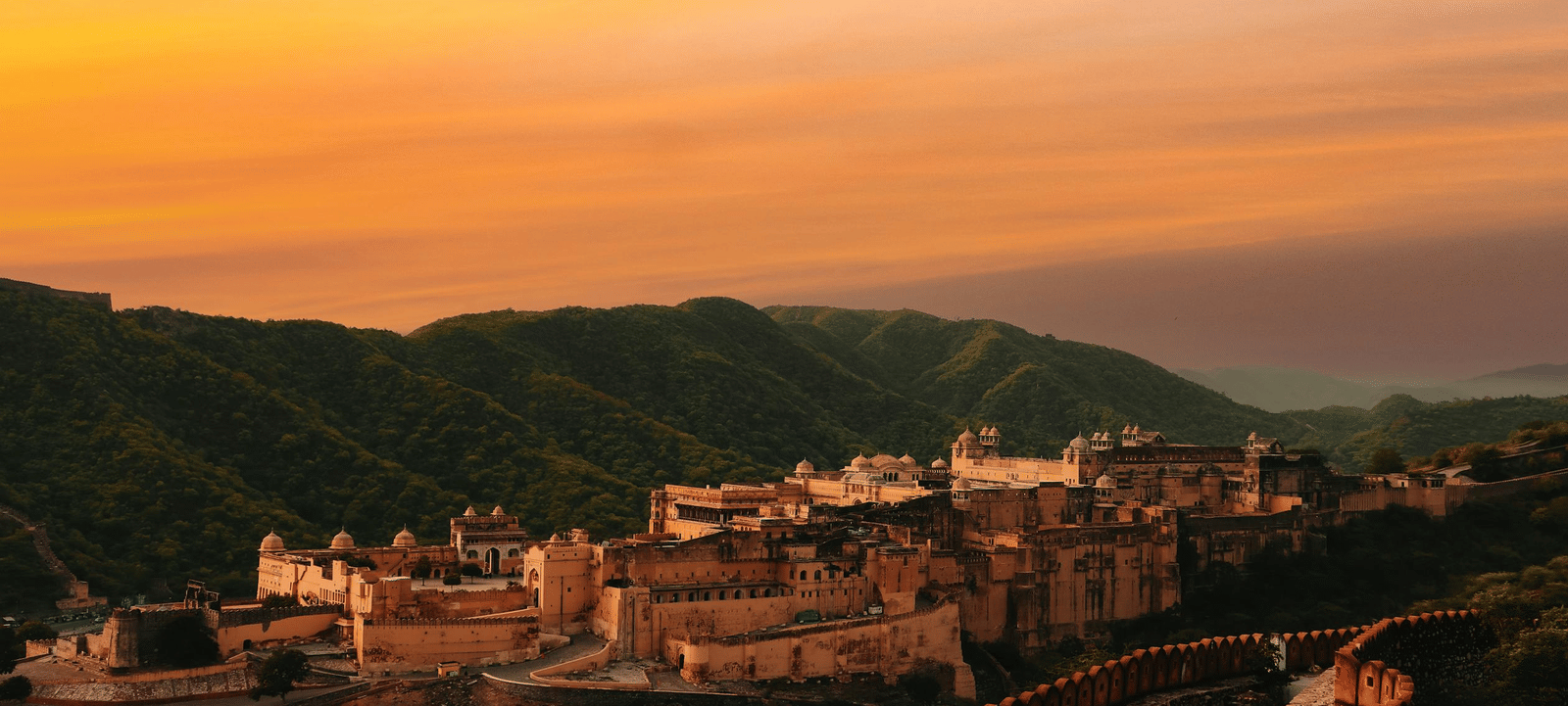 Aerial view of Amber Fort with mountains in the background.