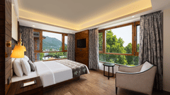 Deluxe room featuring plush bed and couch with a majestic view of the nature