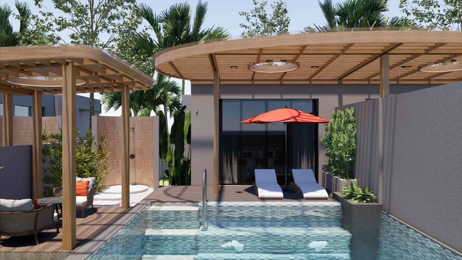 A private pool villa at Ramada Resort by Wyndham Khao Lak, with sun loungers, an umbrella, and lush greenery.