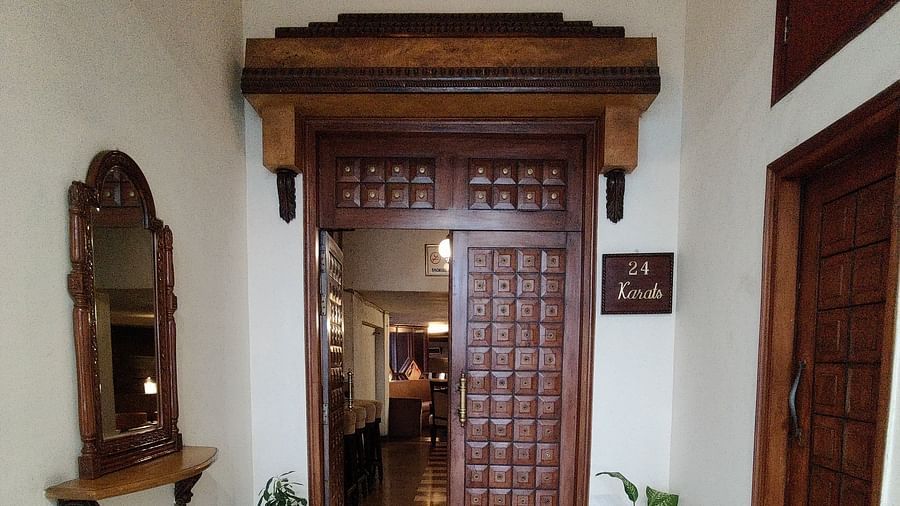 Entrance of the 24 Karats bar where two dark coloured doors are visible with an ornate pattern on the floor - Hotel Gold, Panipat