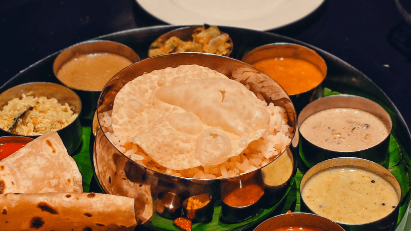 A traditional Indian thali with various savoury dishes served in small bowls on a platter.