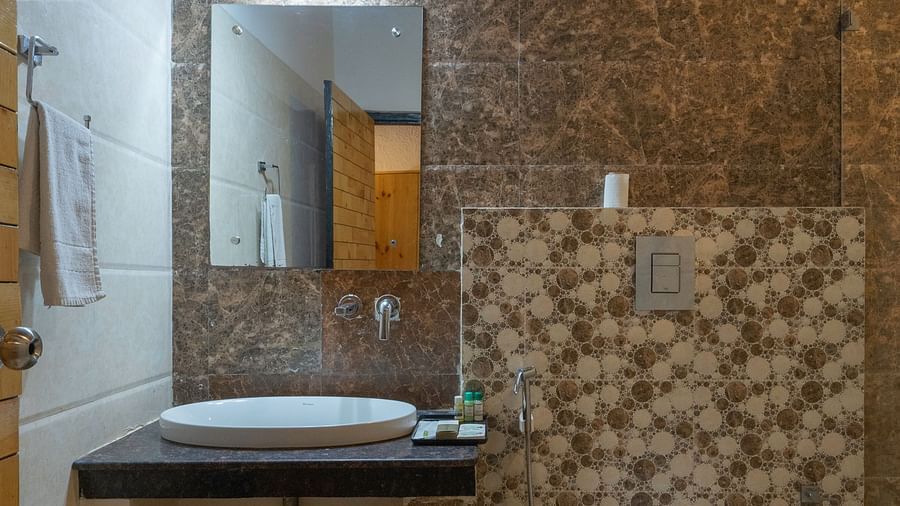 Modern bathroom with stone wall design at The Tattwaa Corbett Spa & Resort.