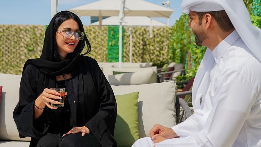 An arabic couple speaking to each other in an al fresco seating at La Patio - La Maison Hotel, Doha