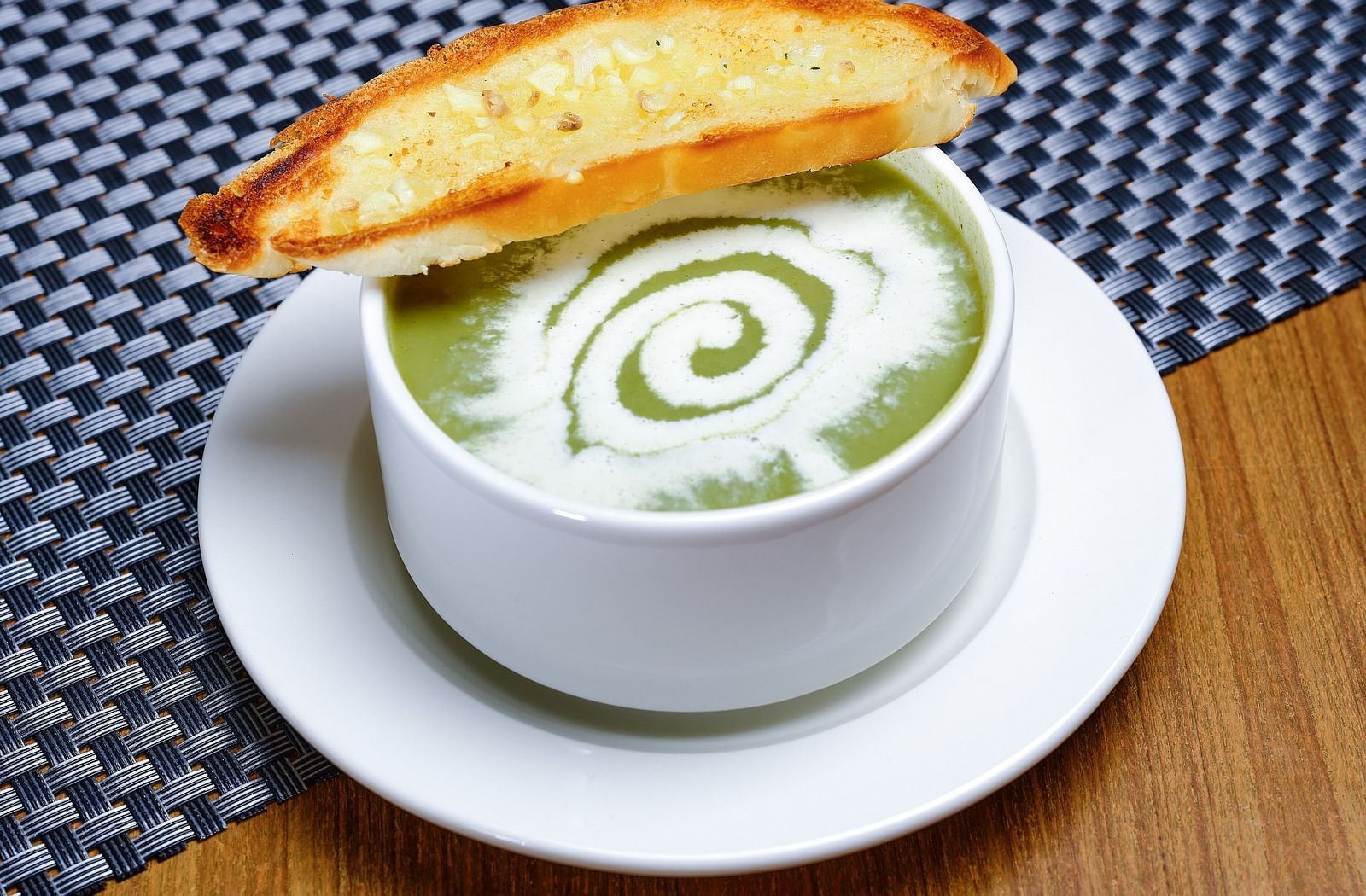 A bowl of soup served alongside a piece of toast - Essentia Premier Hotel, Chennai