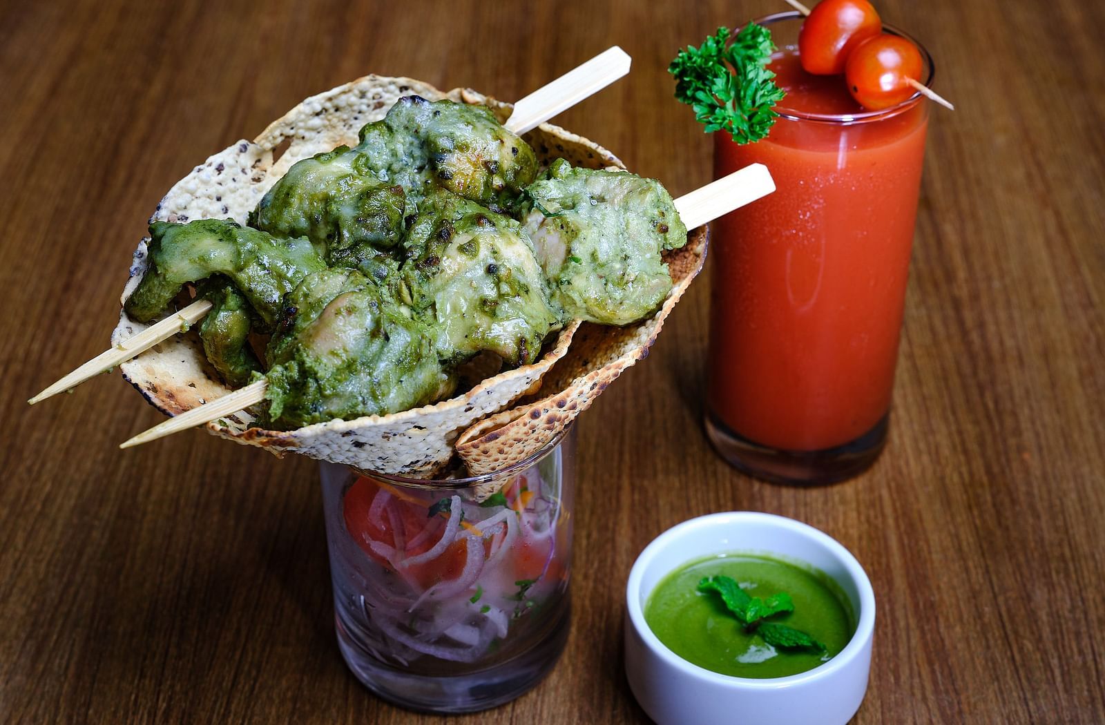 A starter served with mint chutney and a glass of strawberry juice