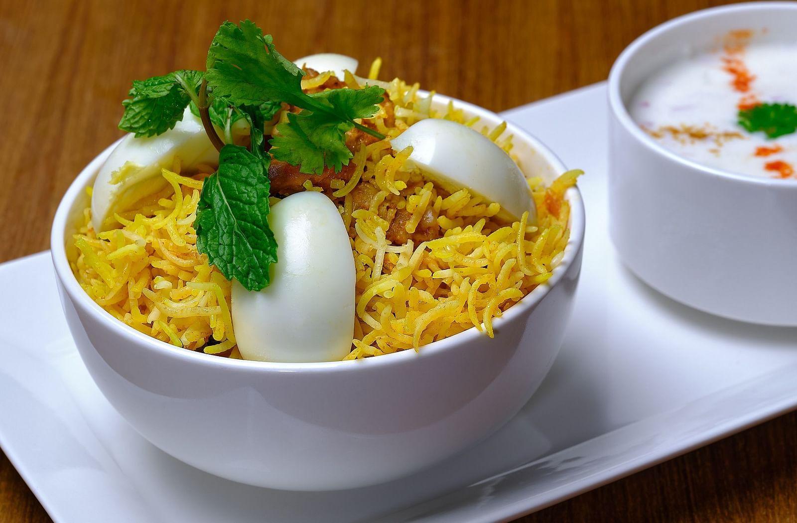 A biryani bowl topped with eggs being served at Essentia Premier Hotel, Chennai