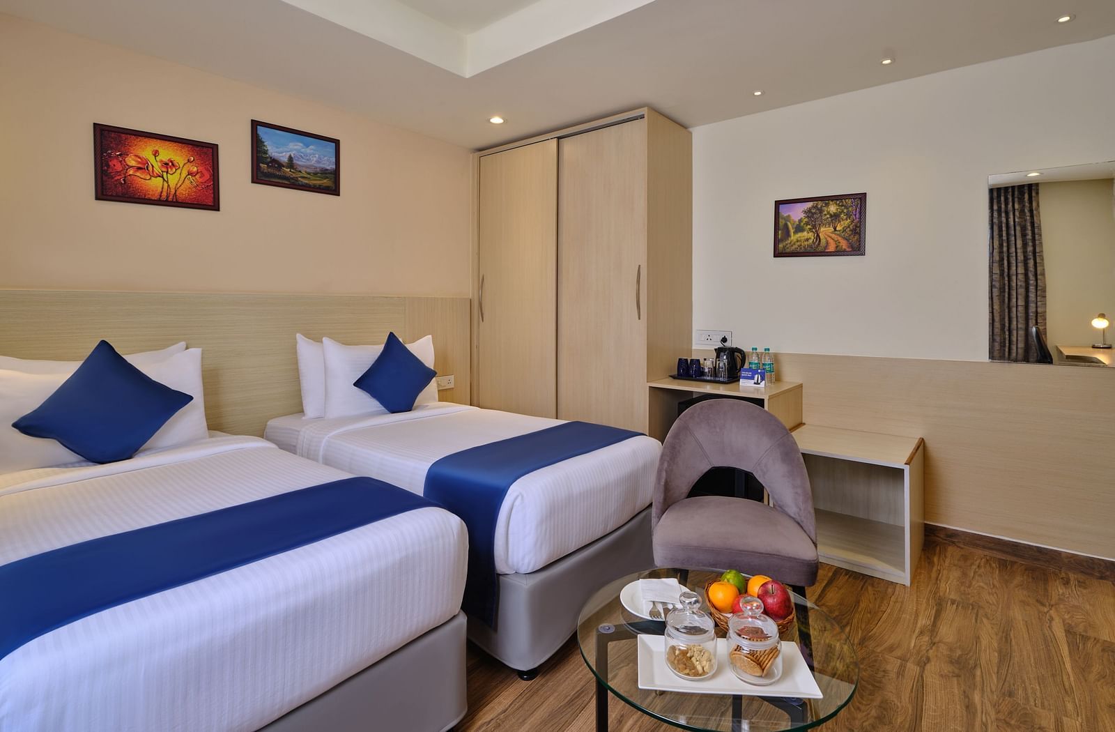 A room at Essentia Premier Hotel, Chennai with twin beds, a wardrobe and a coffee table