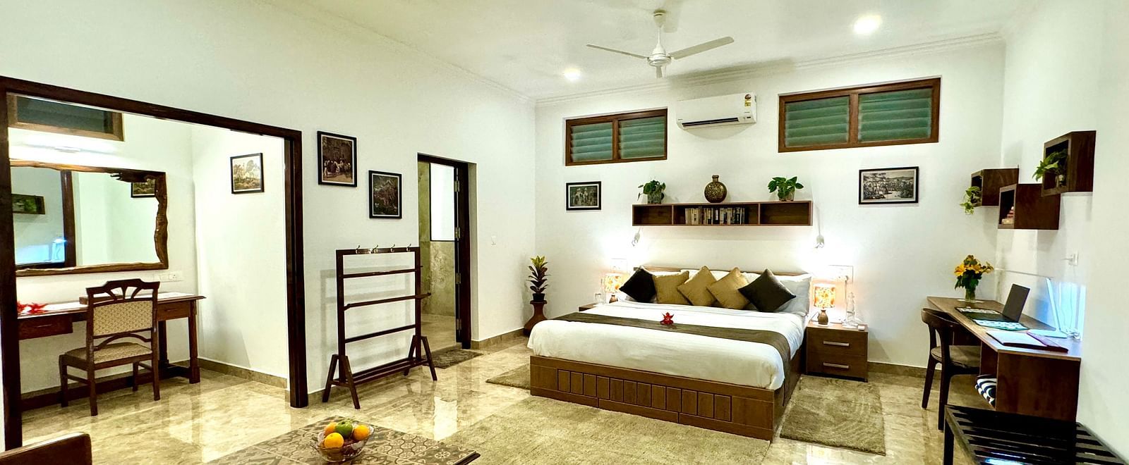 Well-lit bedroom with a double bed, seating area, and various decorative items - BluSalzz Collection - Tranquil Resort, Wayanad