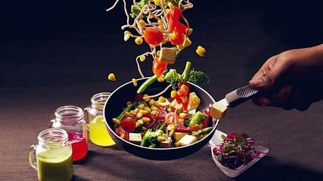 Salad served with an artistic vertical presentation and colourful garnishes.