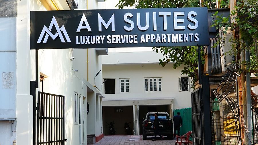 A sign board placed outside a building - A M Suites