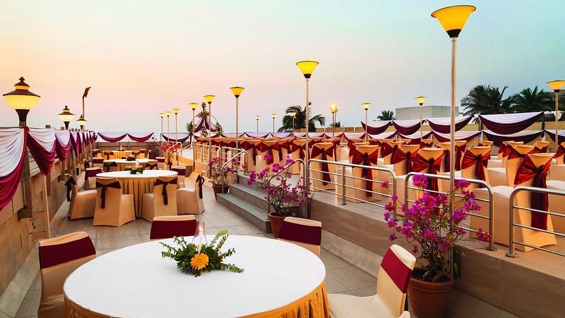 An image of the rooftop banquet hall with round tables, chairs and beautiful decoration - Ramada Plaza by Wyndham Palm Grove