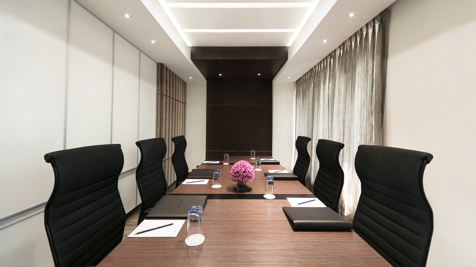 image of a boardroom with note pads on the table at Grand Kakinada by GRT Hotels