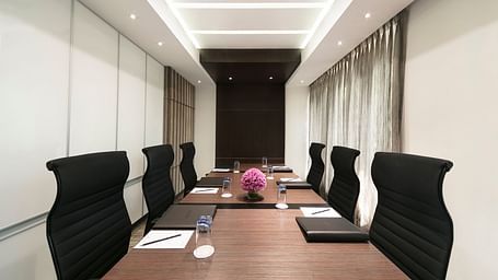 image of a boardroom with note pads on the table at Grand Kakinada by GRT Hotels