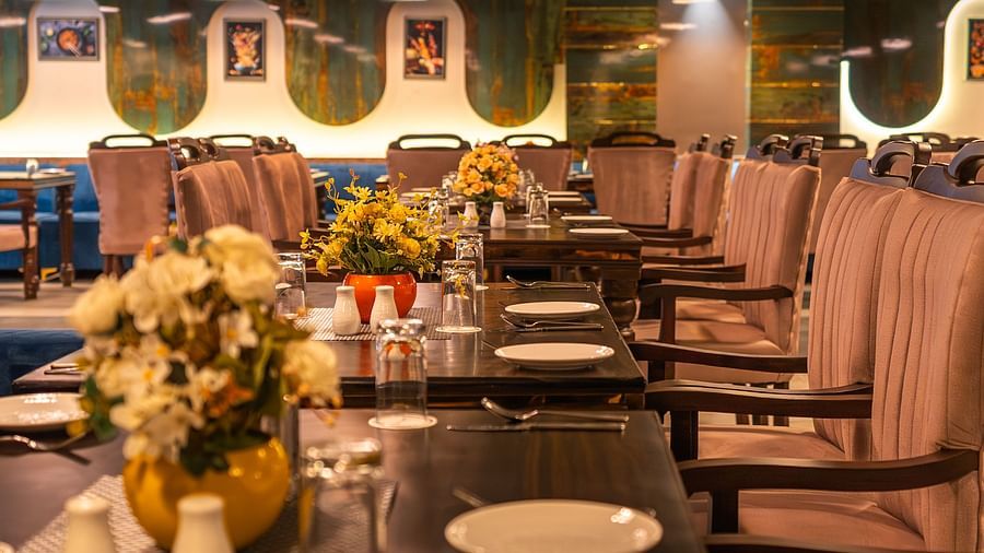 view from the table of the restaurant where flower vases, plates and cutleries are arranged