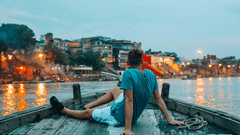 A person relaxing on a boat, gazing at the beautiful ghats of Varanasi.