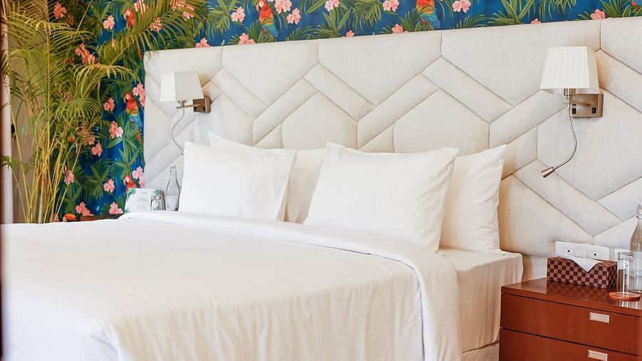 A bedroom with a double bed, side tables and lamps inside terrace suite - Karma Lakelands.