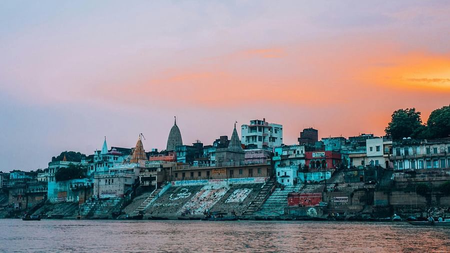 Scenic view of the ghats and historic buildings at sunset along the Ganges River in Varanasi
