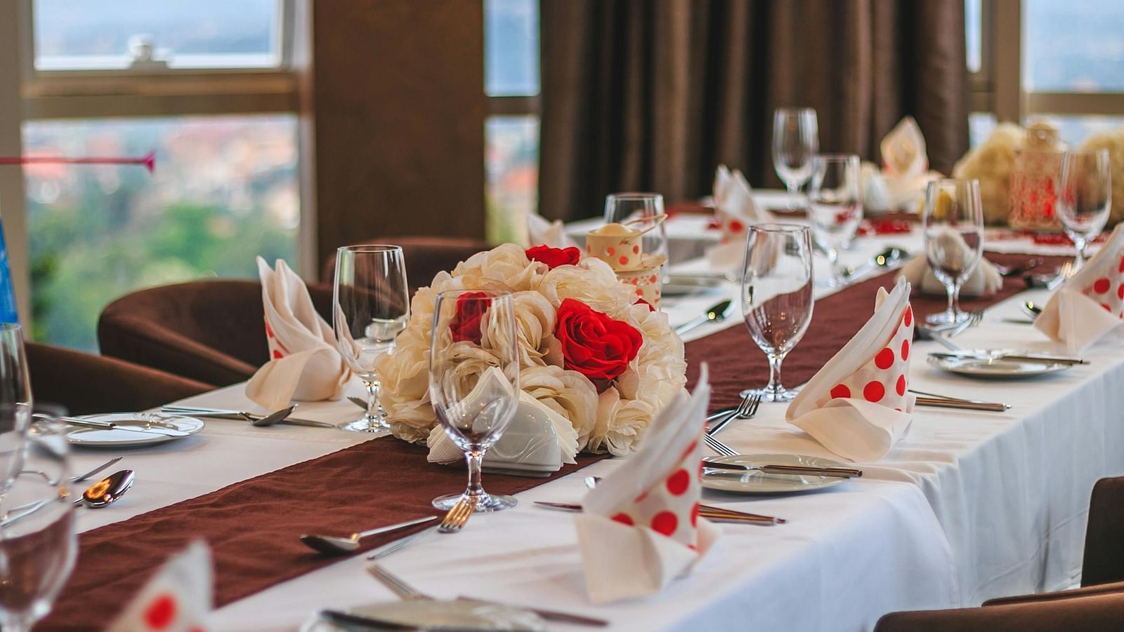 Elegant table setting for a formal event with floral centrepieces and folded napkins.