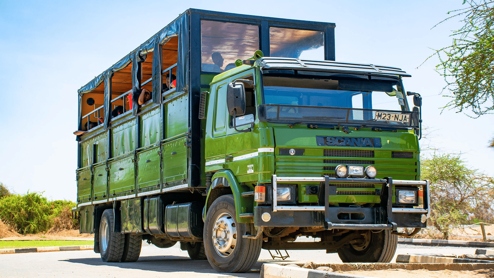 Open-topped canter truck parked outdoors against a clear sky.