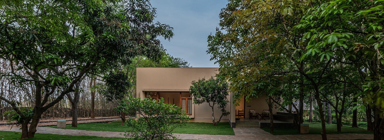 Garden with trees and a building in the background, outdoor landscape, natural setting - Shreyas Retreat