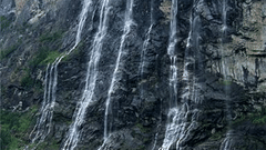 View of water falls cascading down the rocky hills into a waterbody
