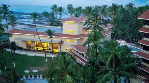 An aerial view of The Retreat Hotel and Convention Centre, with palm trees and a pool area in the foreground.