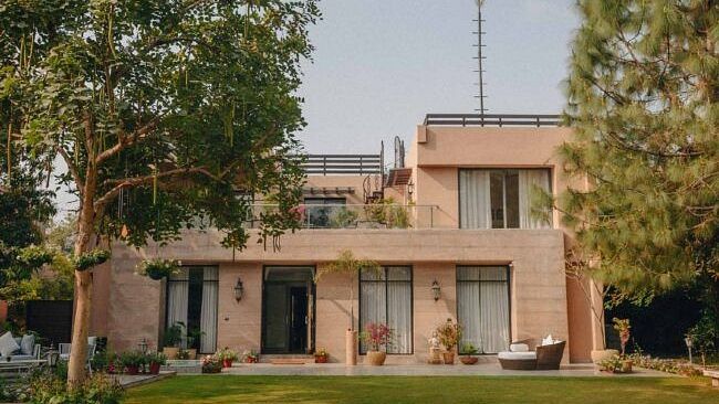 Exterior view of a villa building with a large lawn and trees surrounding it at Karma Chalets.