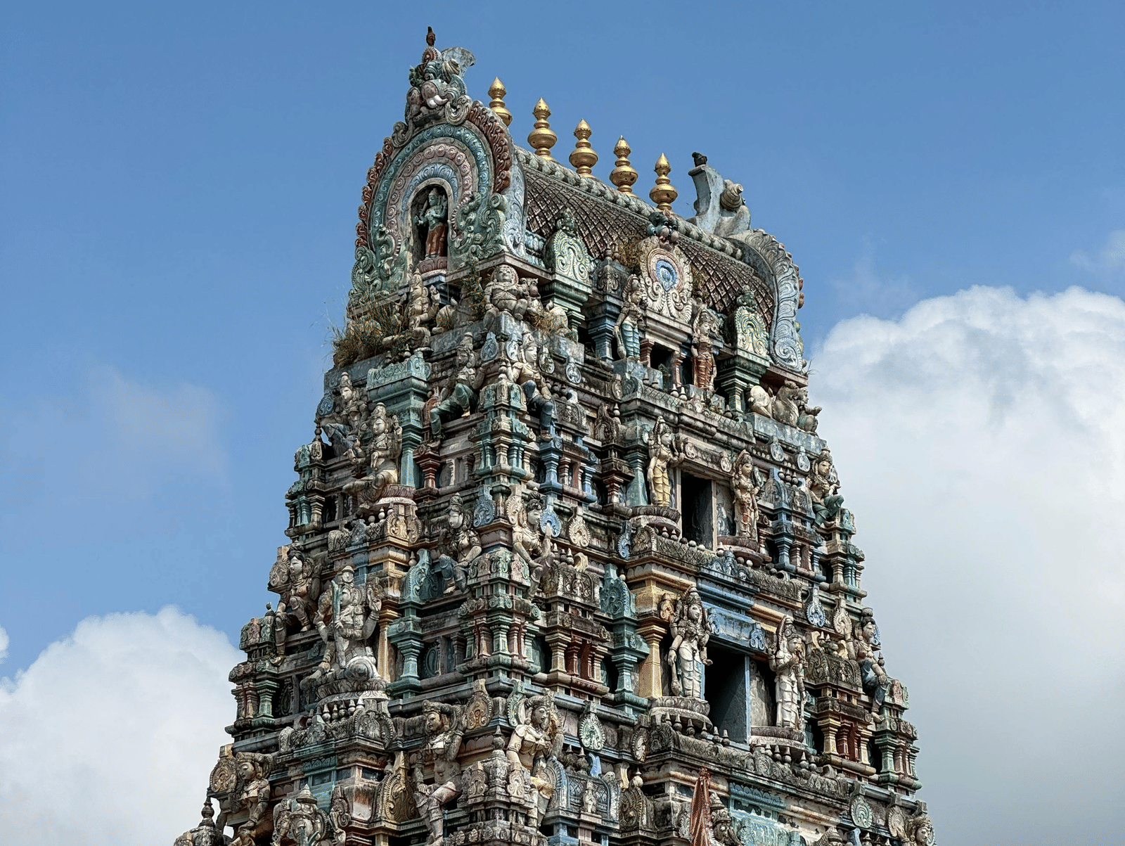 Majestic South Indian temple gopuram rising into a bright blue sky.