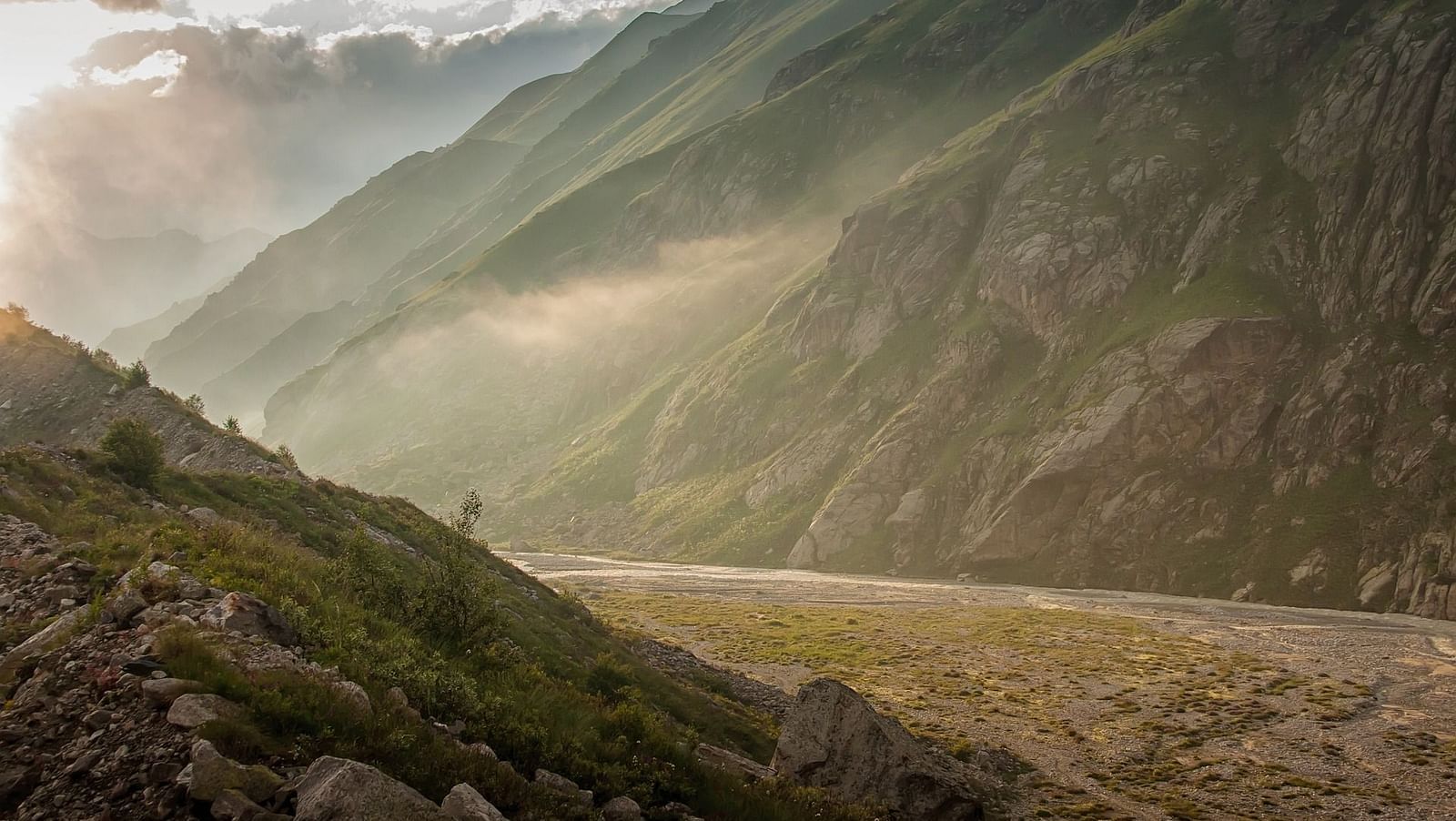 an image of the mountains with sun's rays reflecting on the side