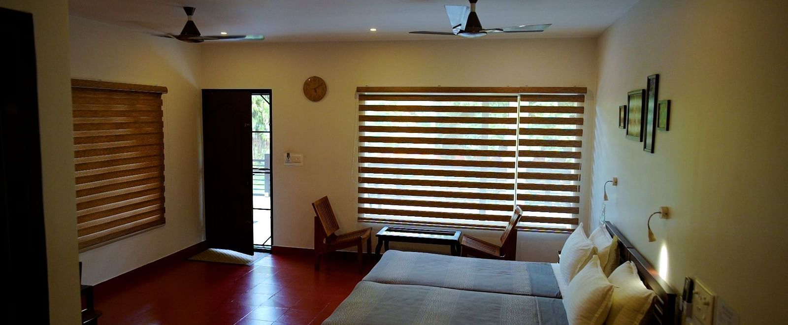 A living area with a couch, a window with blinds, and a ceiling fan.