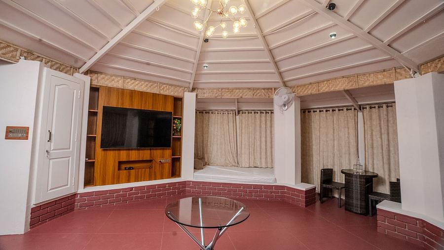 An interior shot of a gazebo that has a TV on the wall and a chandelier with in-built beds | Habba Dates Villa, Hampasandra