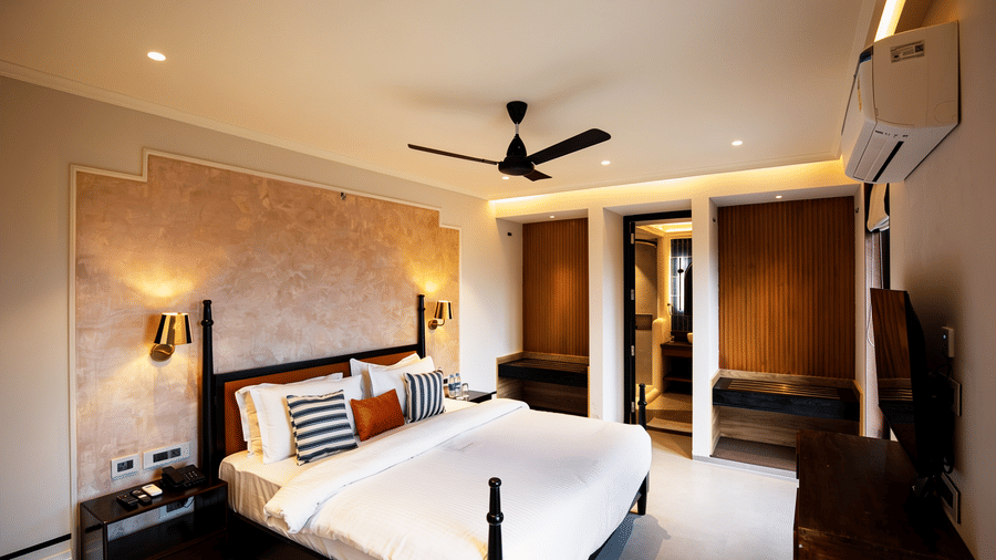 A well-lit bedroom featuring a king size bed, 2 wooden wardrobes, and a black ceiling fan at The Sierra - By The Lake.
