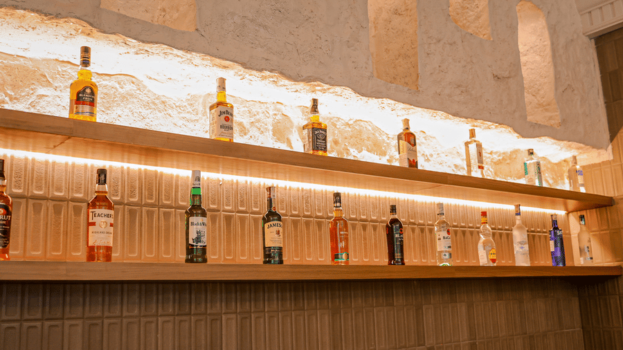 Backlit display shelves with bottles at Hotel Mumbai House Digha, Airoli.