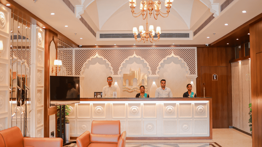 Reception desk with chandeliers and seating area at Hotel Mumbai House Digha, Airoli.