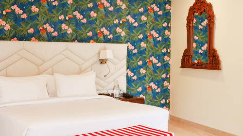 A double bed with side table and lamp in view inside the terrace suite - Karma Lakelands.